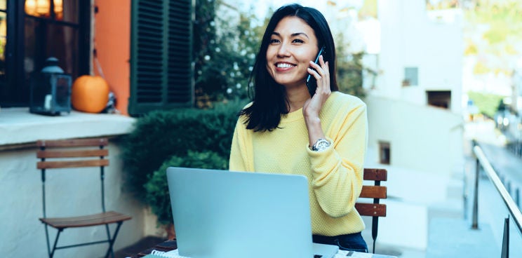 A smiling woman talking over the phone